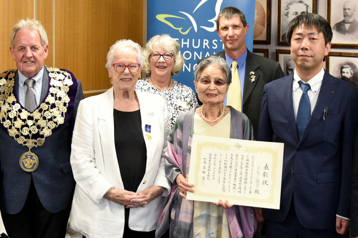 姉妹都市交流に尽力したリーキー・筆子さんへ「大熊町町制施行70周年記念表彰」の表彰状が贈られました。団員が持参し、リーキーさんは「光栄です。心から感謝します」と話しました。