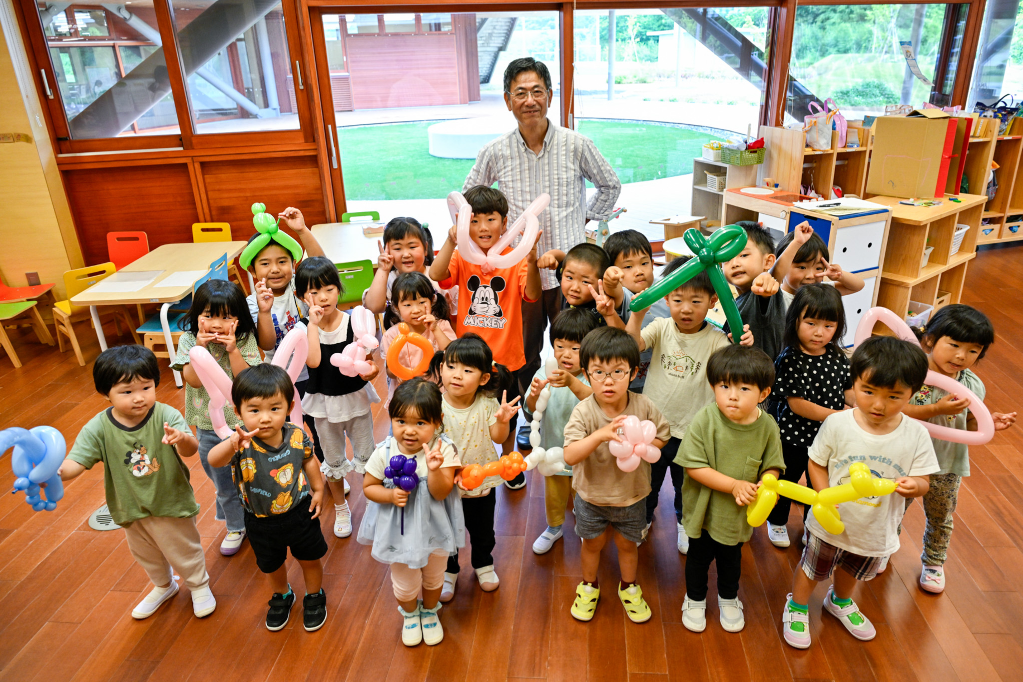 坂口さん（中央）と、プレゼントされたバルーンアートを 手に記念撮影に収まる園児たち