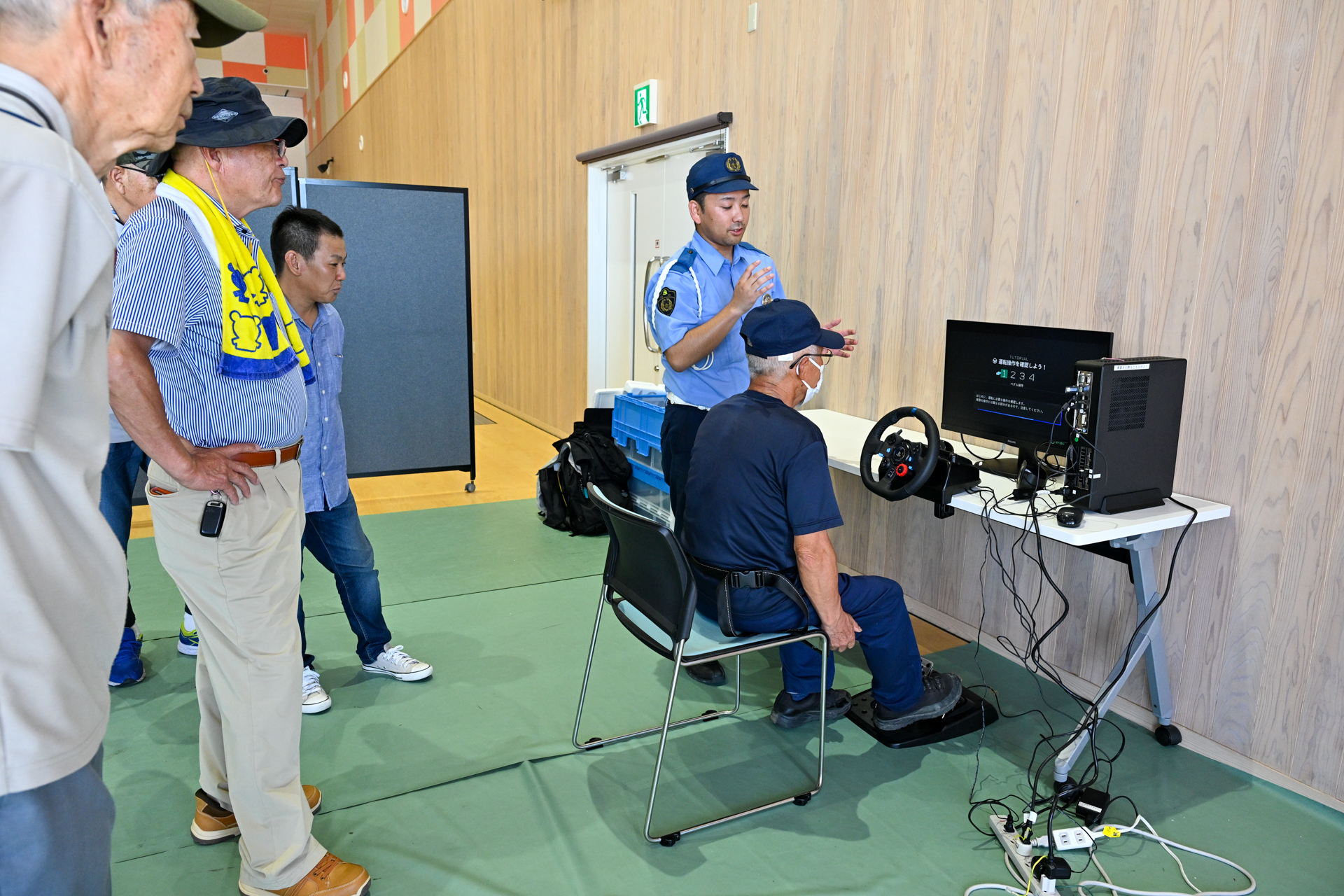 運転シミュレータの説明を受けた来場者ら