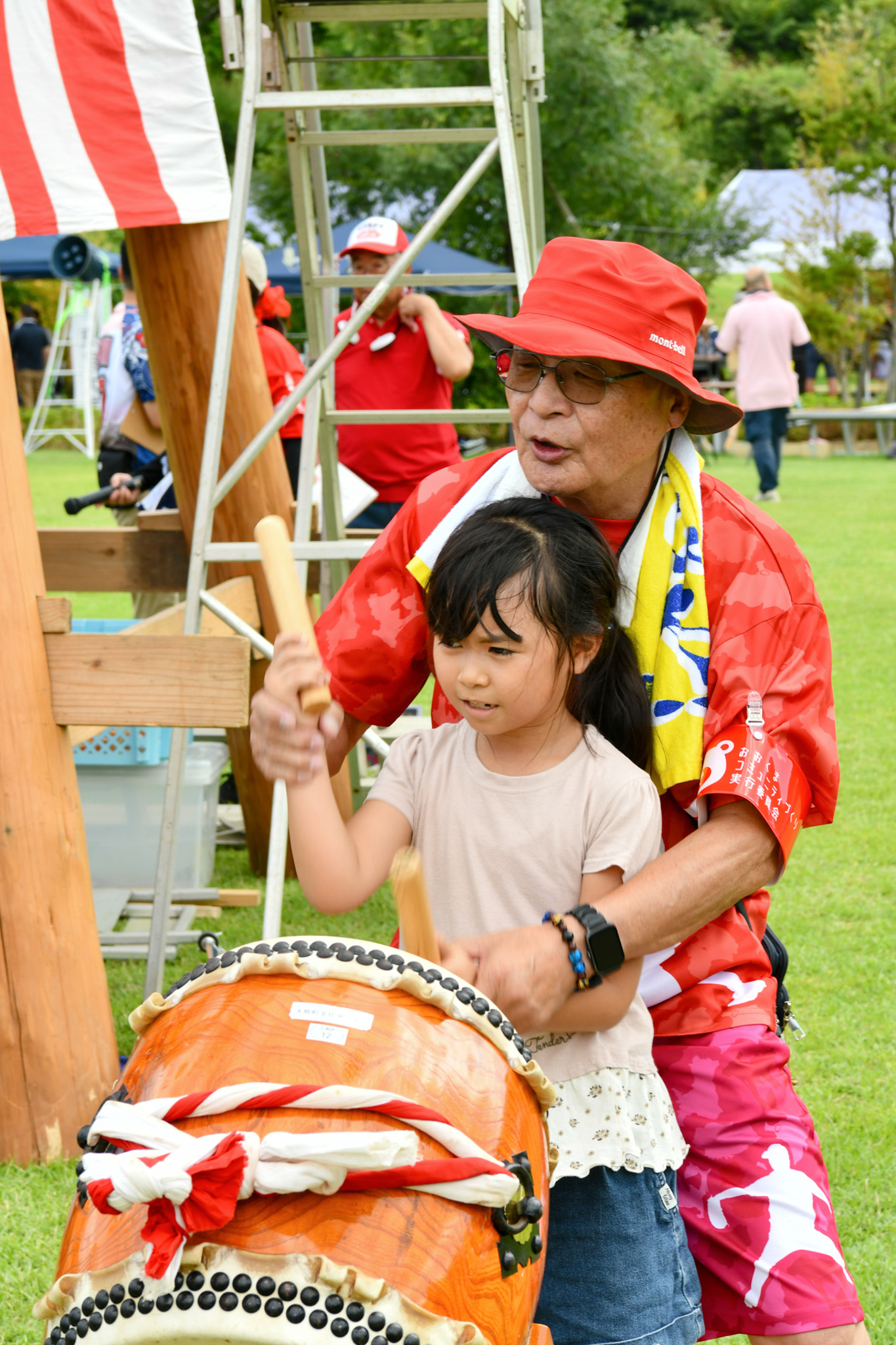 宮太鼓を前に、町民の手ほどきを受けながらバチの使い方を学ぶ子ども。真剣な表情で、一打一打を力強く打っていました。