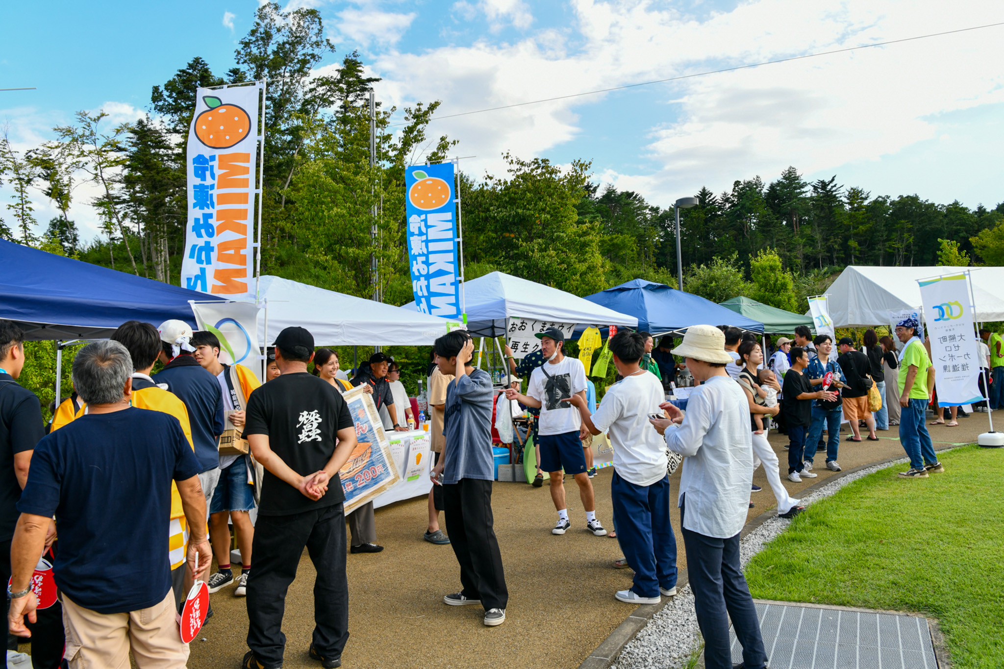 写真は、会場に並んだ出展ブースの様子です。学生の体験ブースや地元企業の飲食ブースが並び、懐かしい顔を見つけて会話が弾むなど、自然と交流が生まれていました。