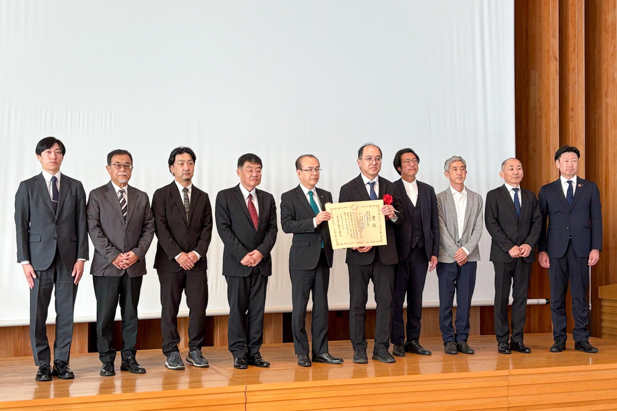 記念撮影に納まった吉田町長(左から5人目)と設計・施工業者ら