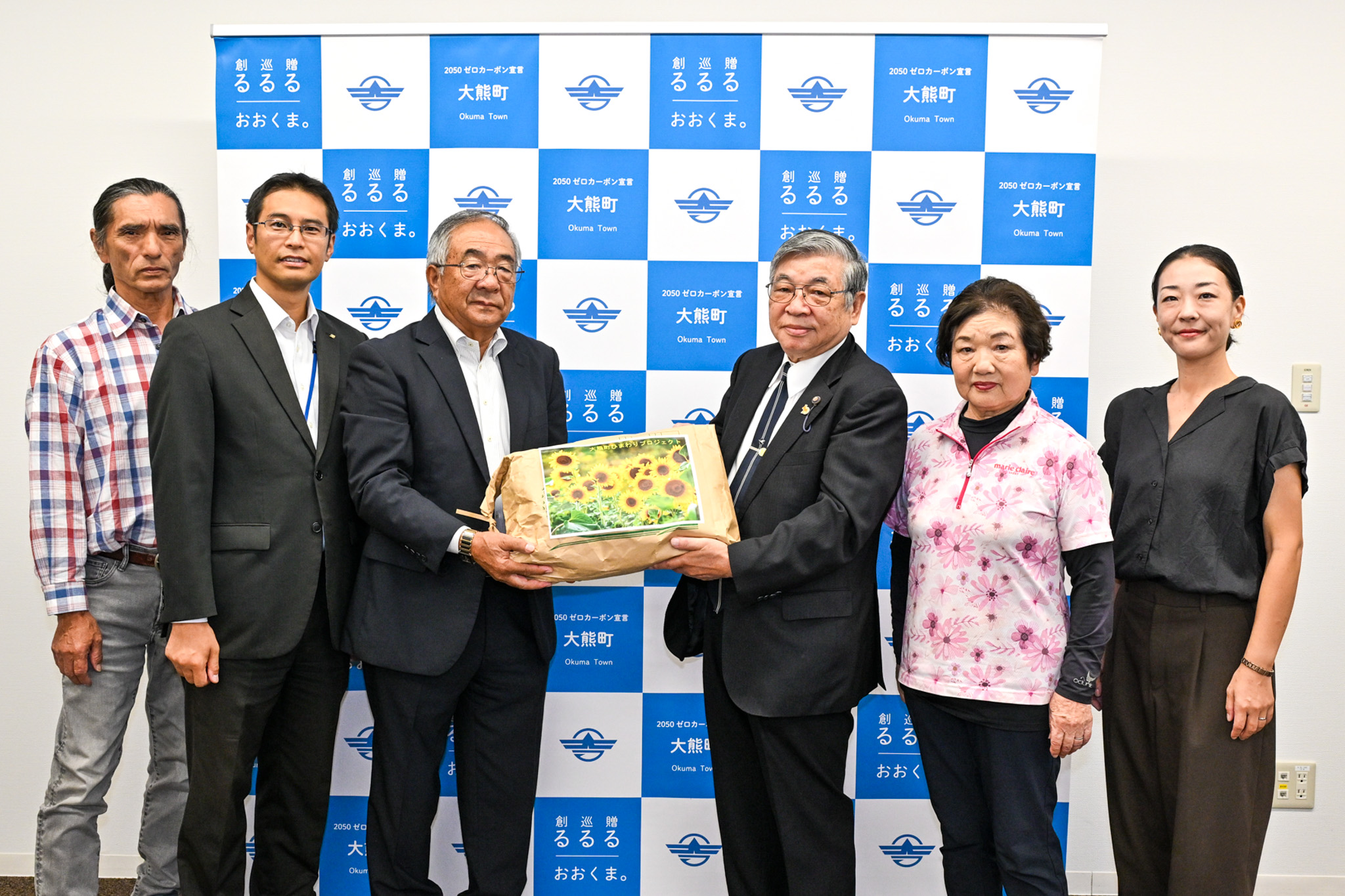 ヒマワリの種を受け取った鈴木副理事（右から3人目）