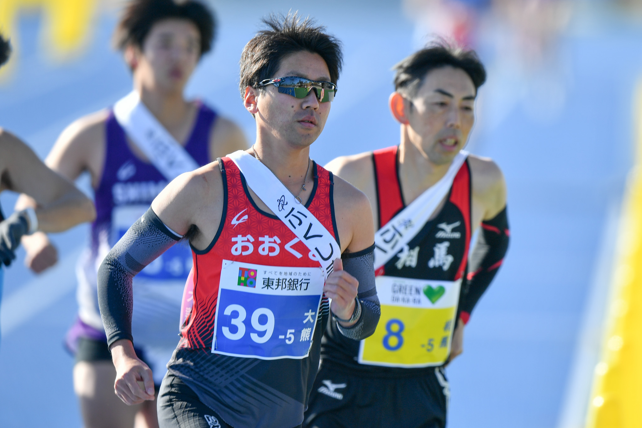 サングラスをかけ前を見つめる吉田選手。両脇や後方に選手が迫る中を走り抜きました。