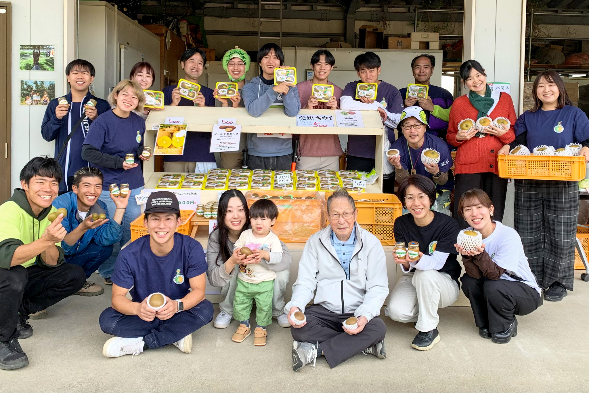 直売所で記念撮影に納まる関本元樹さん（前列左から3人目）ら関係者