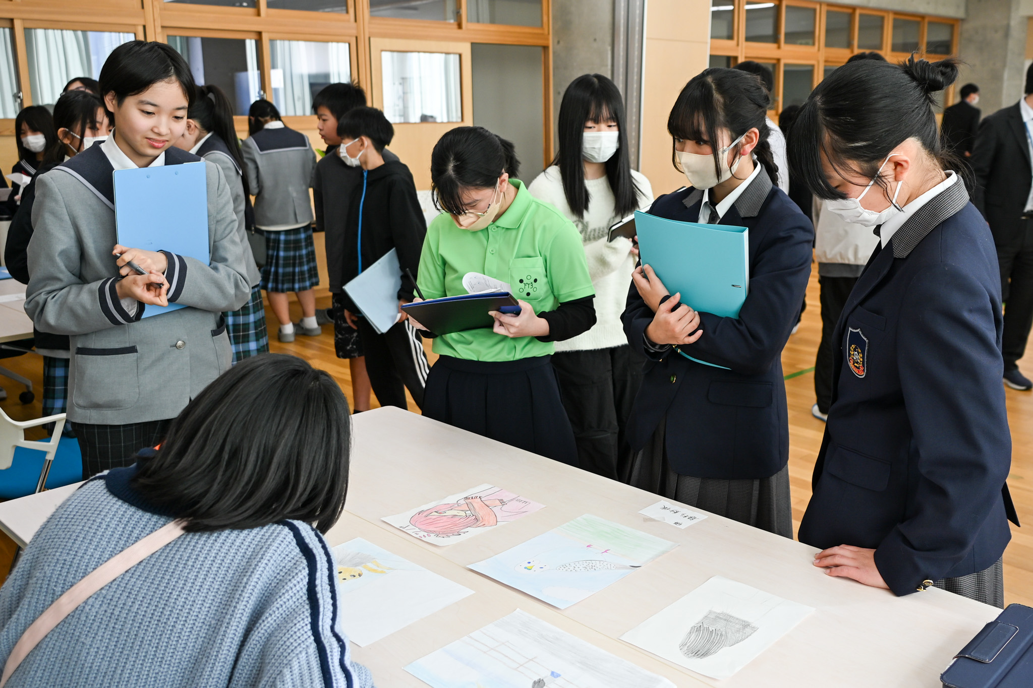 研究テーマの展示物を見る生徒ら