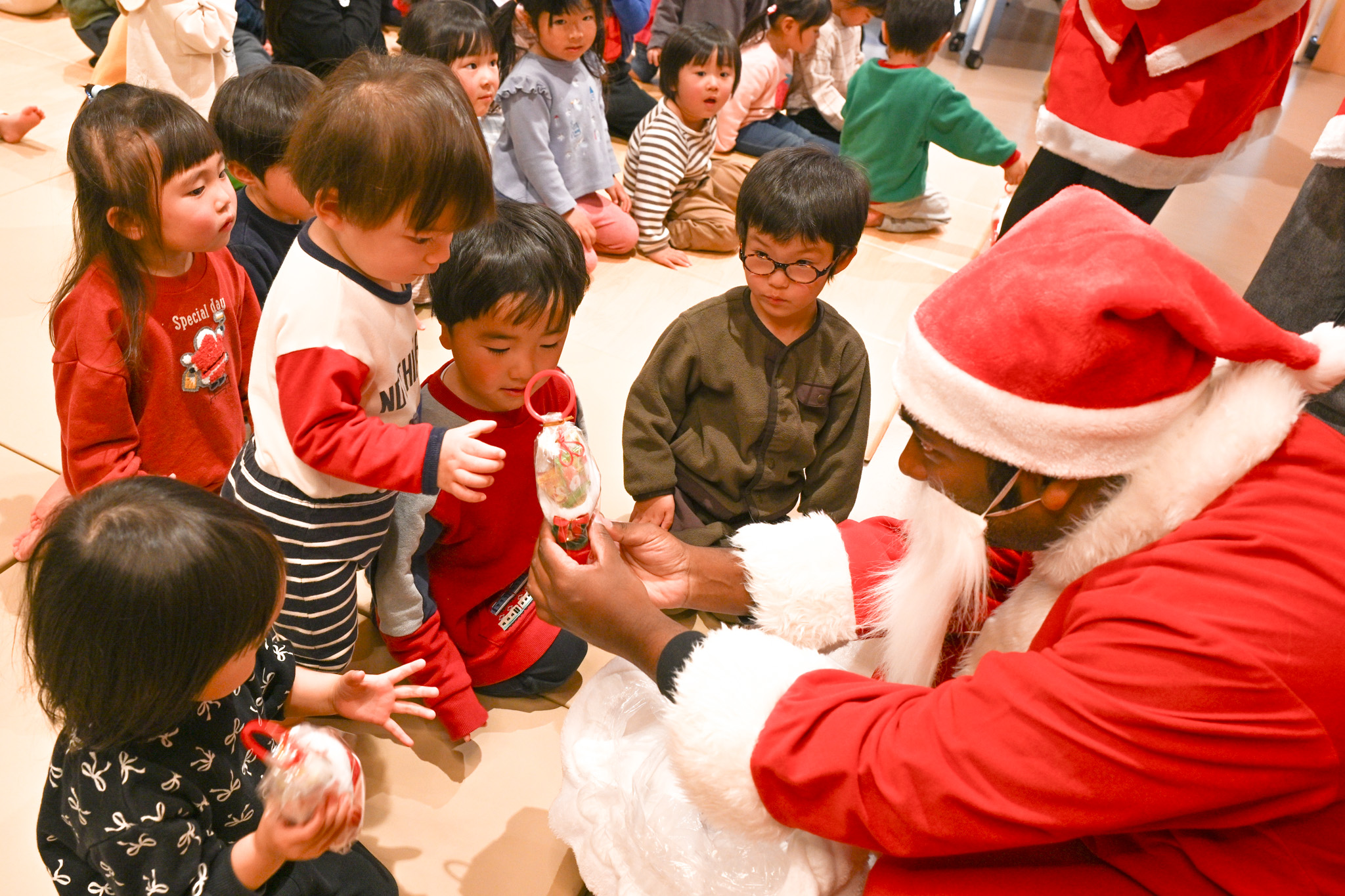 来園したサンタからプレゼントを受け取る園児たち