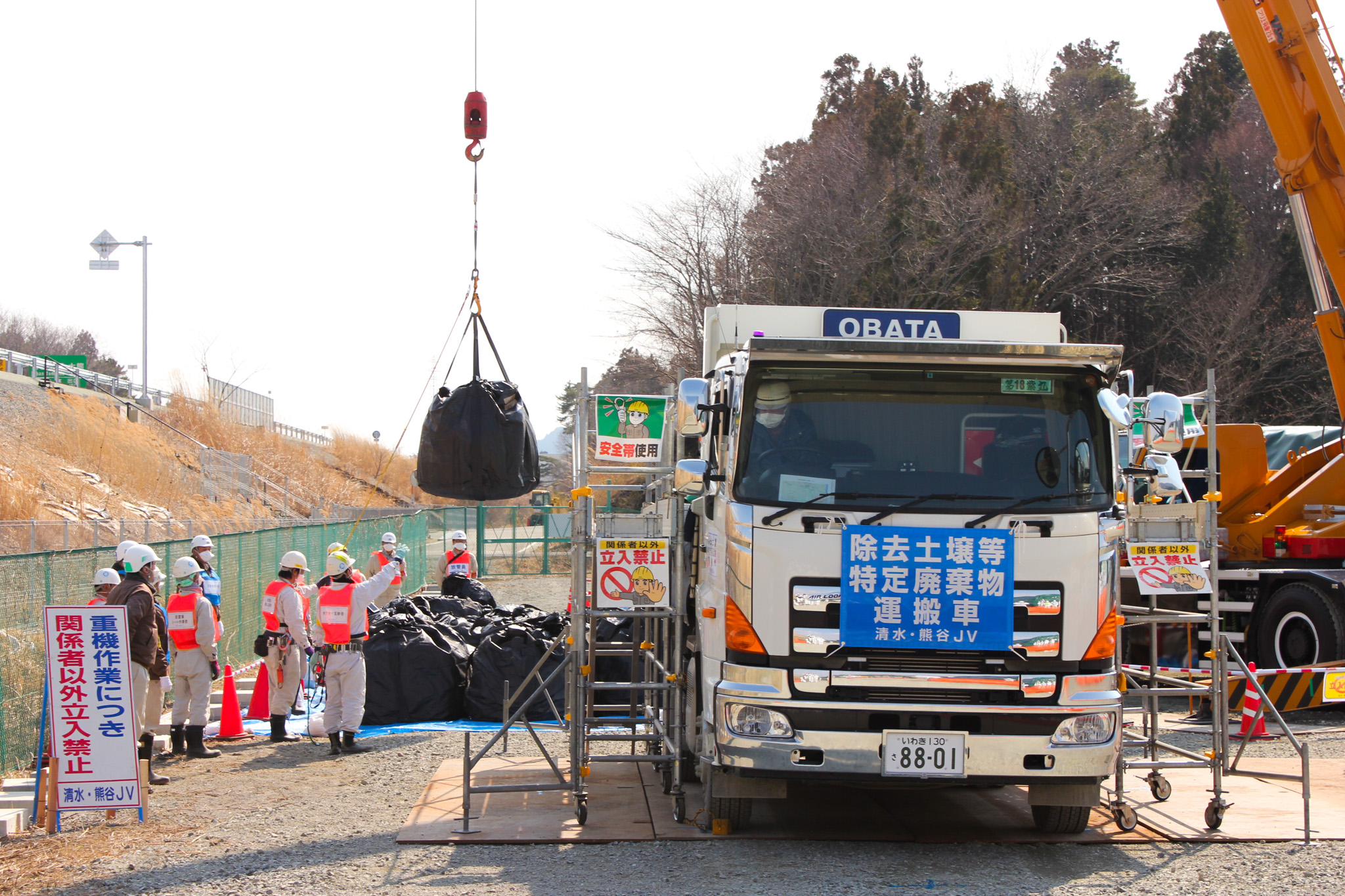 トラックから吊り上げられ、敷地内に搬入される廃棄物
