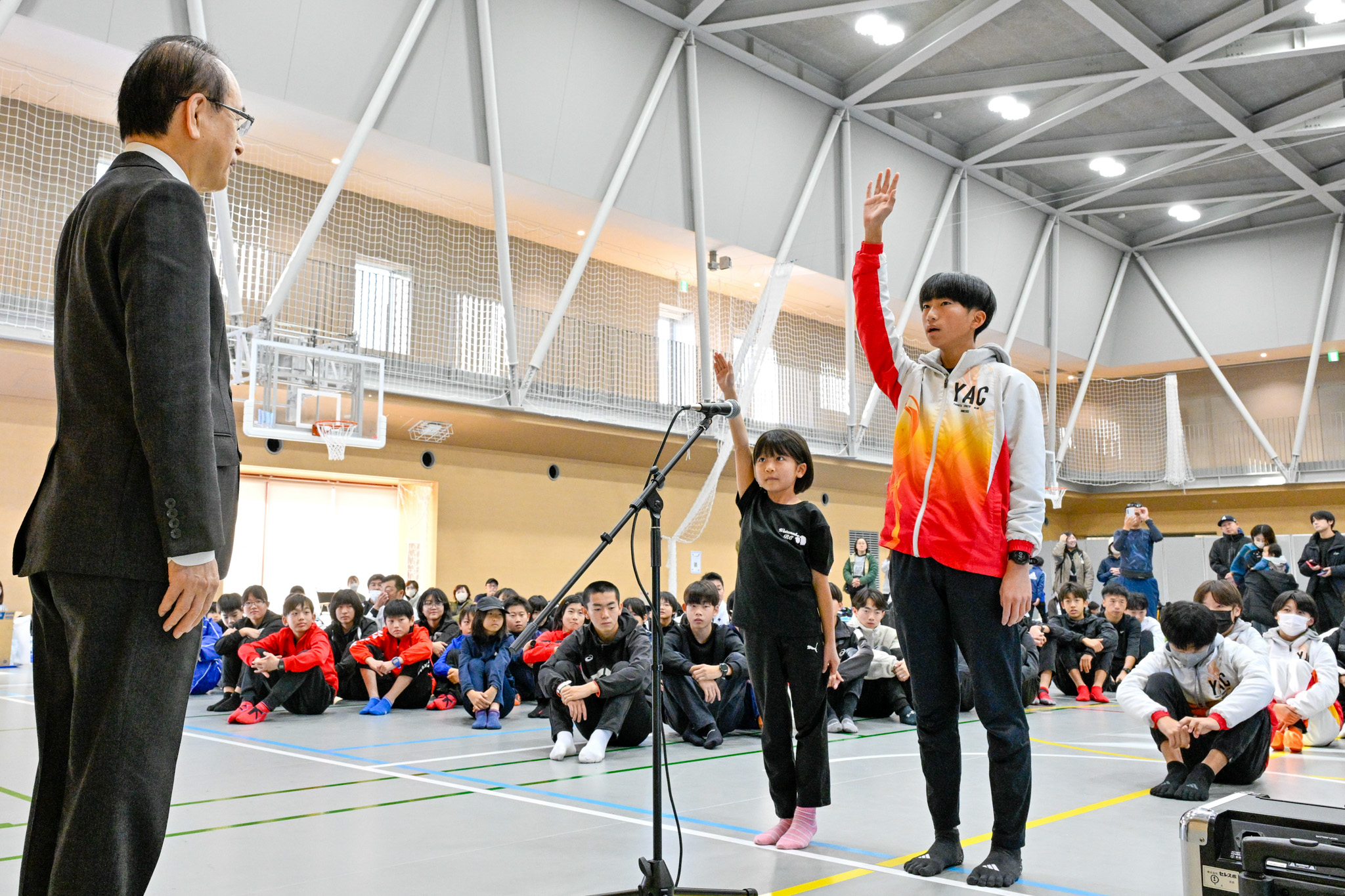 小学生の部と一般の部の代表が、吉田町長を前に右手を伸ばし、はっきりとした声で選手宣誓を行っています。