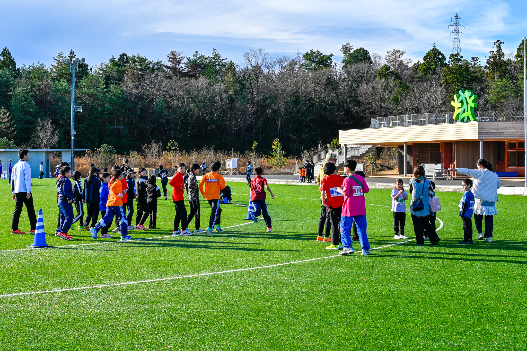 町内で再開されて3回目となった今大会には、全84チーム327人が参加しました。選手たちはスタート前のウォーミングアップとして、グラウンド内を軽く走っています。