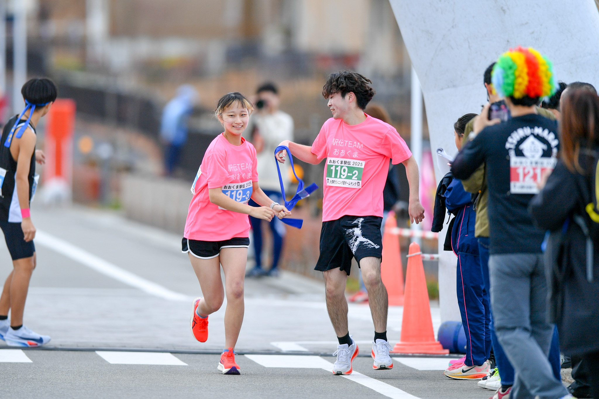 中継地点でタスキを受け取った選手が、次の区間へ走り出します。