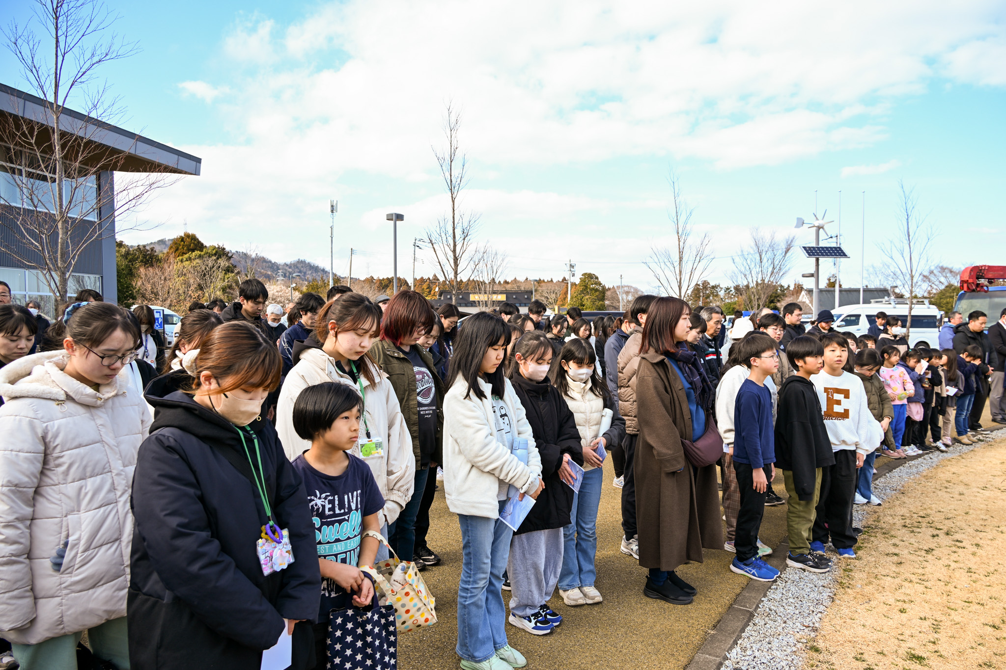 午後2時46分、消防ラッパが響く中、黙とうを捧げる参加者