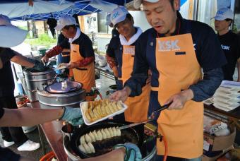 会場で餃子を焼くボランティア社員の写真