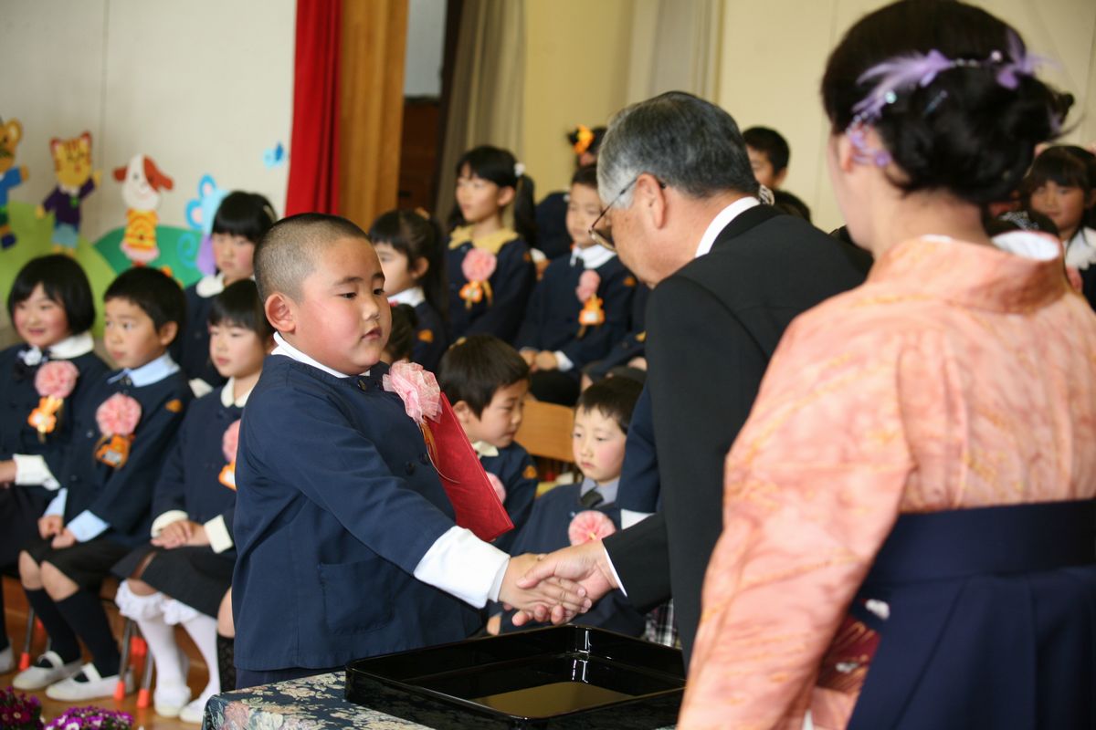 終了証書を受け取った後、園長先生と握手を交わす卒園児