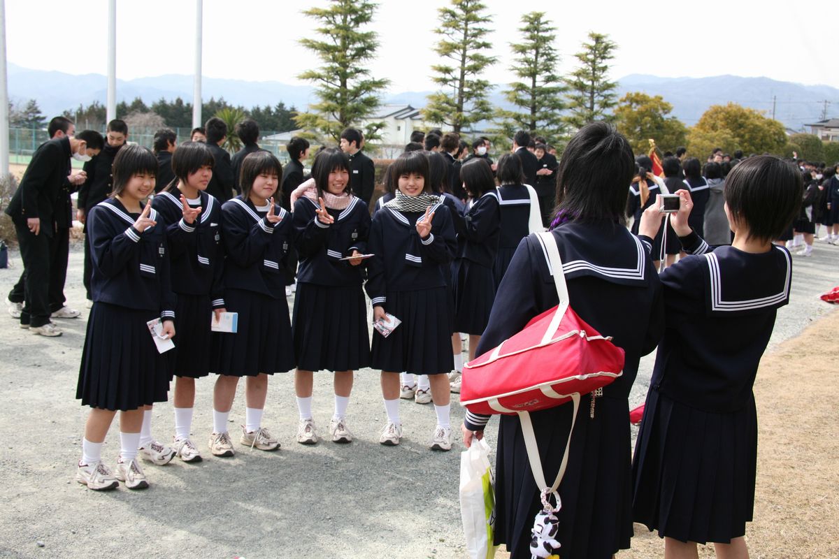 中学校生活の最後に記念撮影をする卒業生