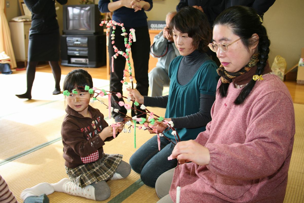 丁寧に団子が付けられたミズノキを持つ親子