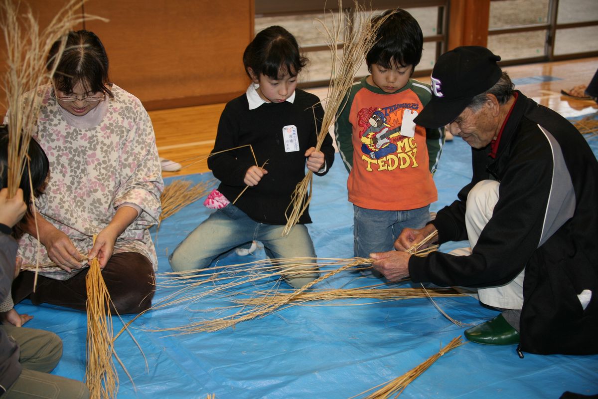 指導するお年寄りを真剣な目で見る子どもたち