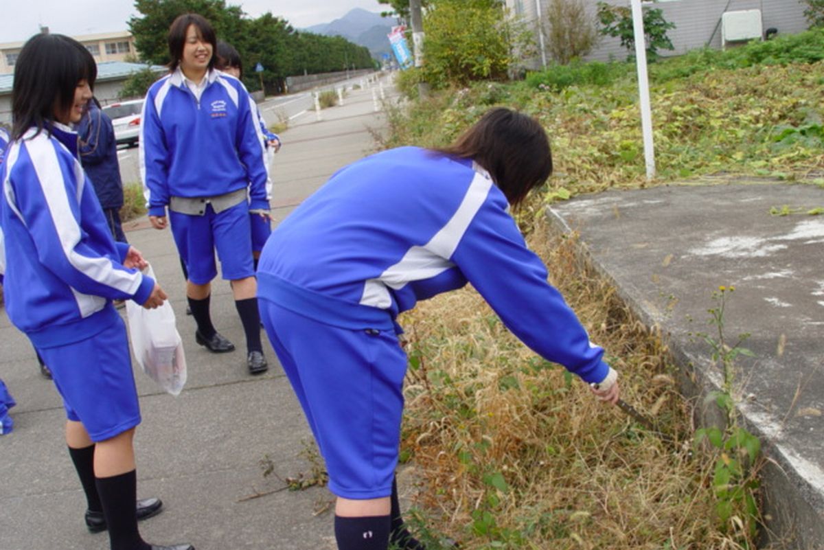 道路脇のゴミを探し清掃する生徒たち