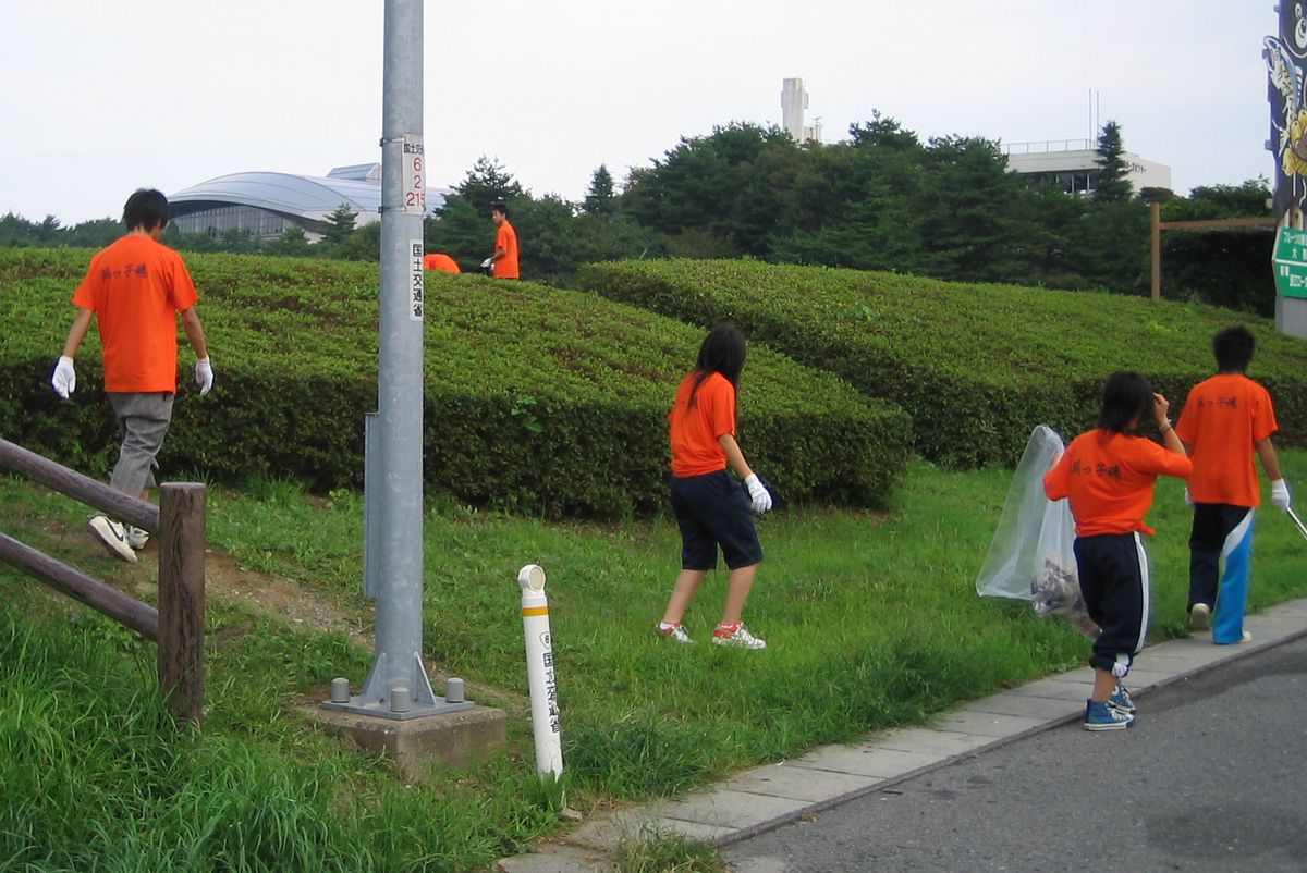 ゴミ袋を持ち、軍手をかけて町内を清掃する双葉翔陽高校生