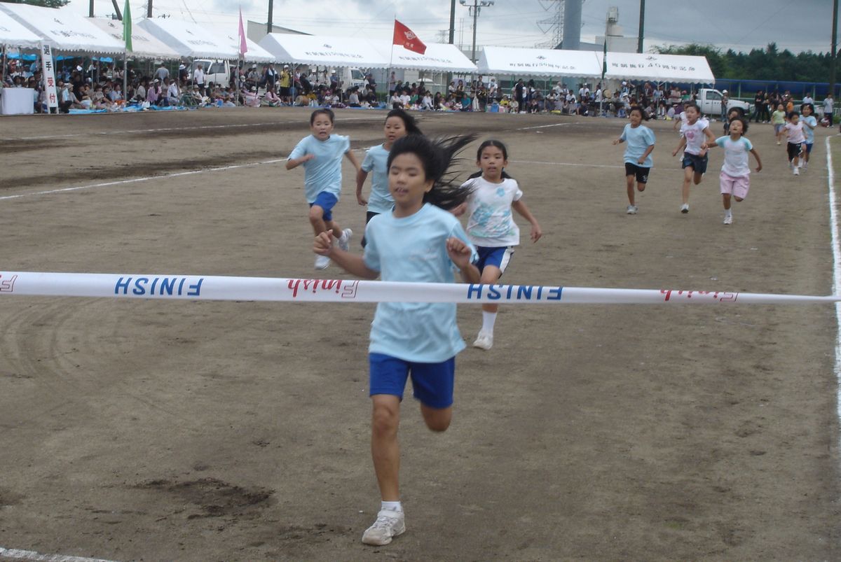 「200メートル走」1番でゴールテープを切る児童