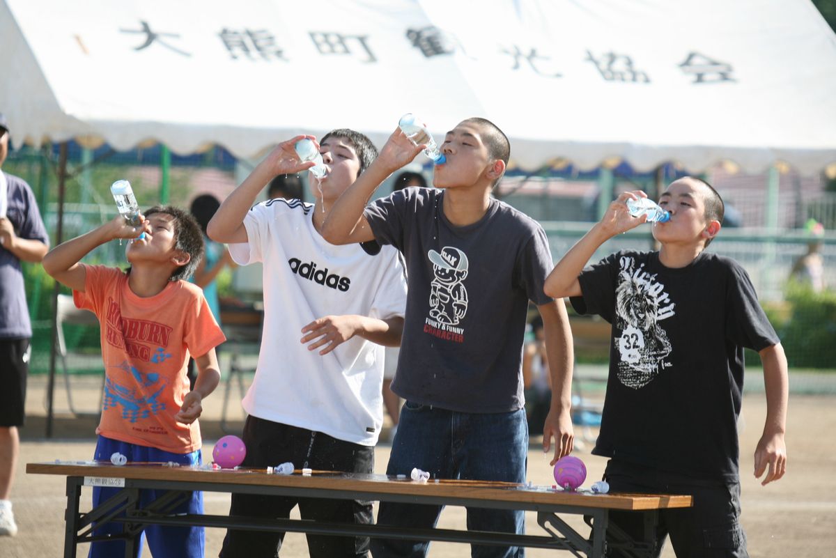 「夏の鉄人レース」でラムネの早飲みに挑戦する参加者