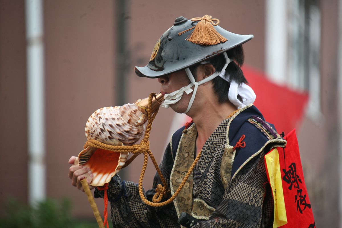 凱旋行列で法螺貝を吹く騎馬武者