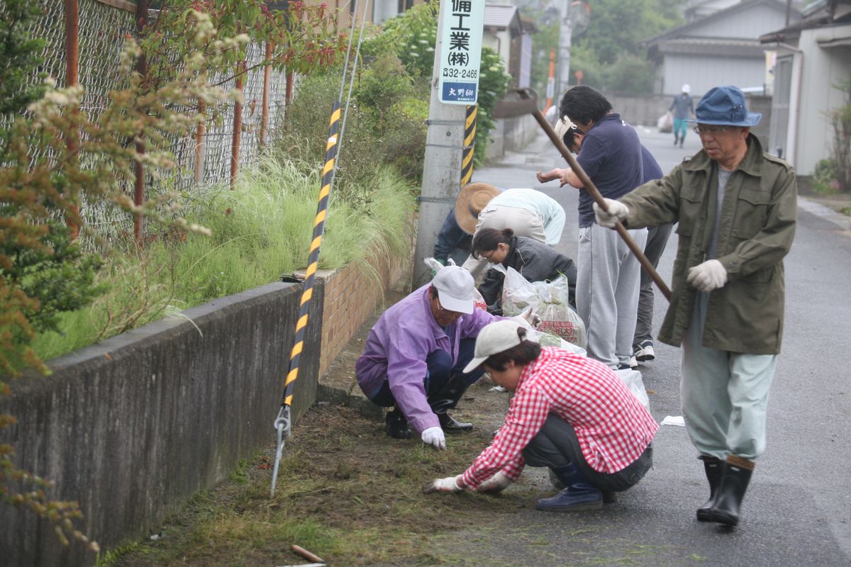 ゴミ袋やゴミばさみを持ち、町内の清掃活動をする参加者