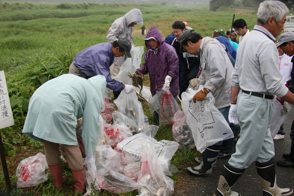 それぞれ拾い集めたゴミを一か所に集める参加者たち