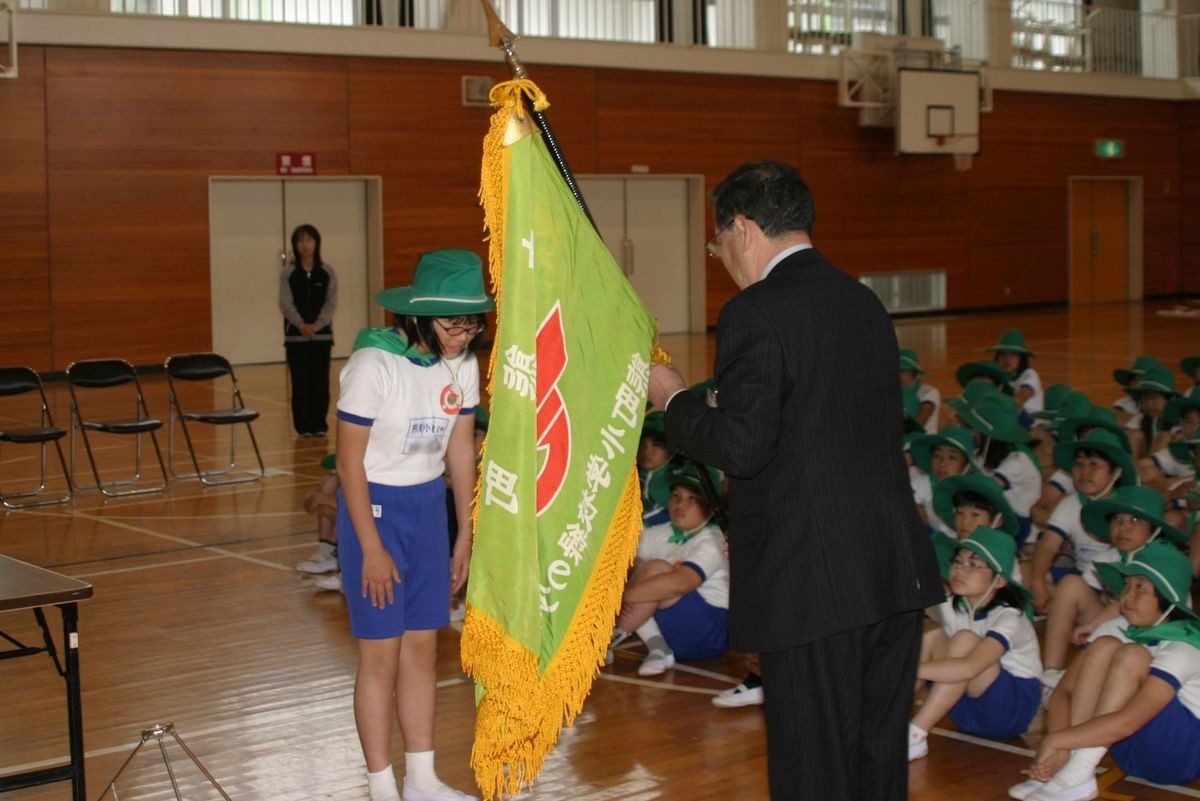 渡辺町長から団旗を贈られる「緑の少年団」副団長
