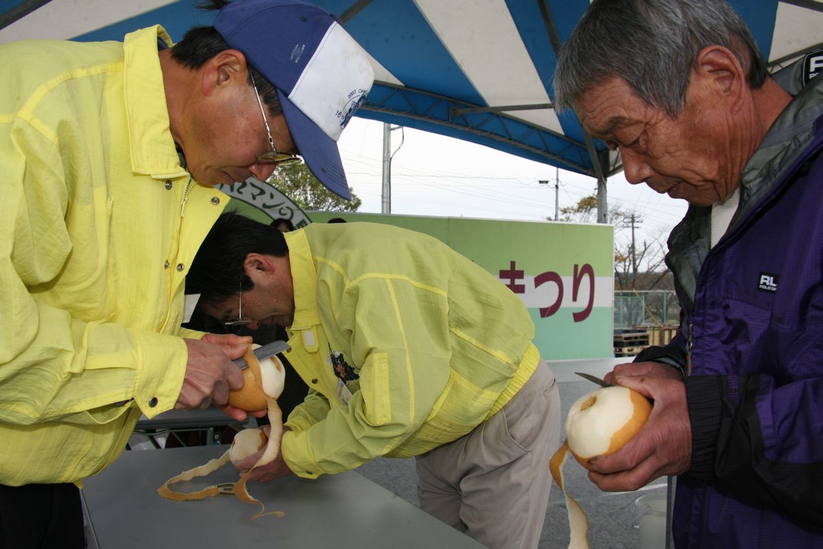 「大熊梨皮むき大会」で真剣に皮をむく参加者