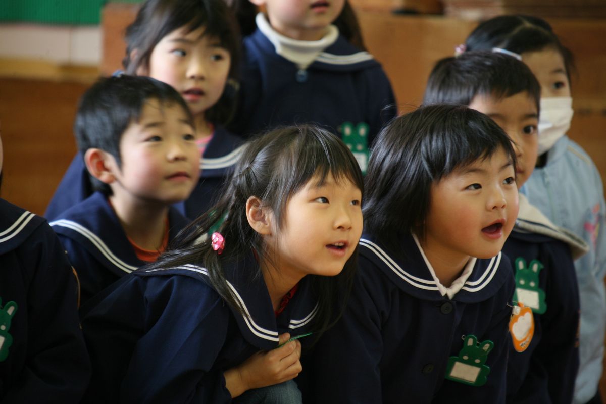 身を乗り出すように人形劇に引き込まれる園児