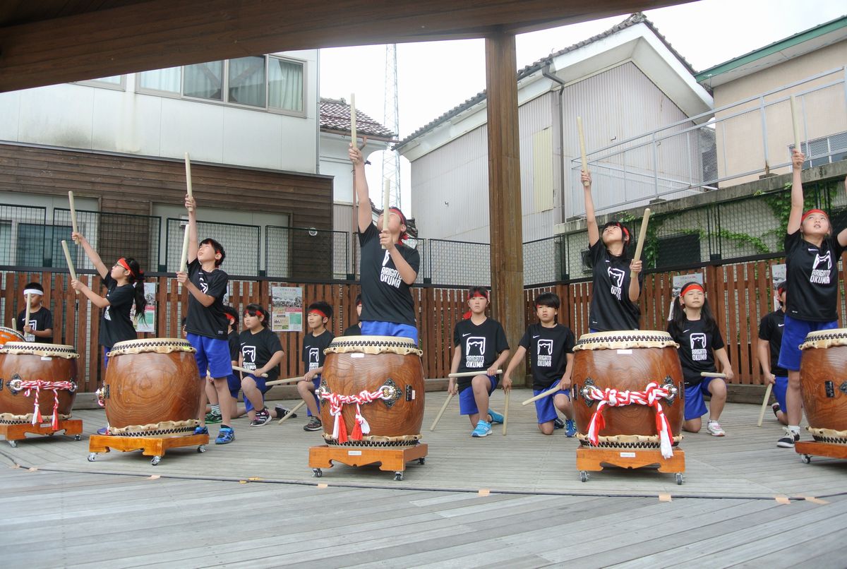 演奏中、空に向かい桴（ばち）を高く掲げる児童