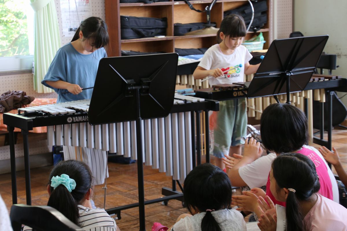 合奏で鉄琴、木琴を奏でる児童