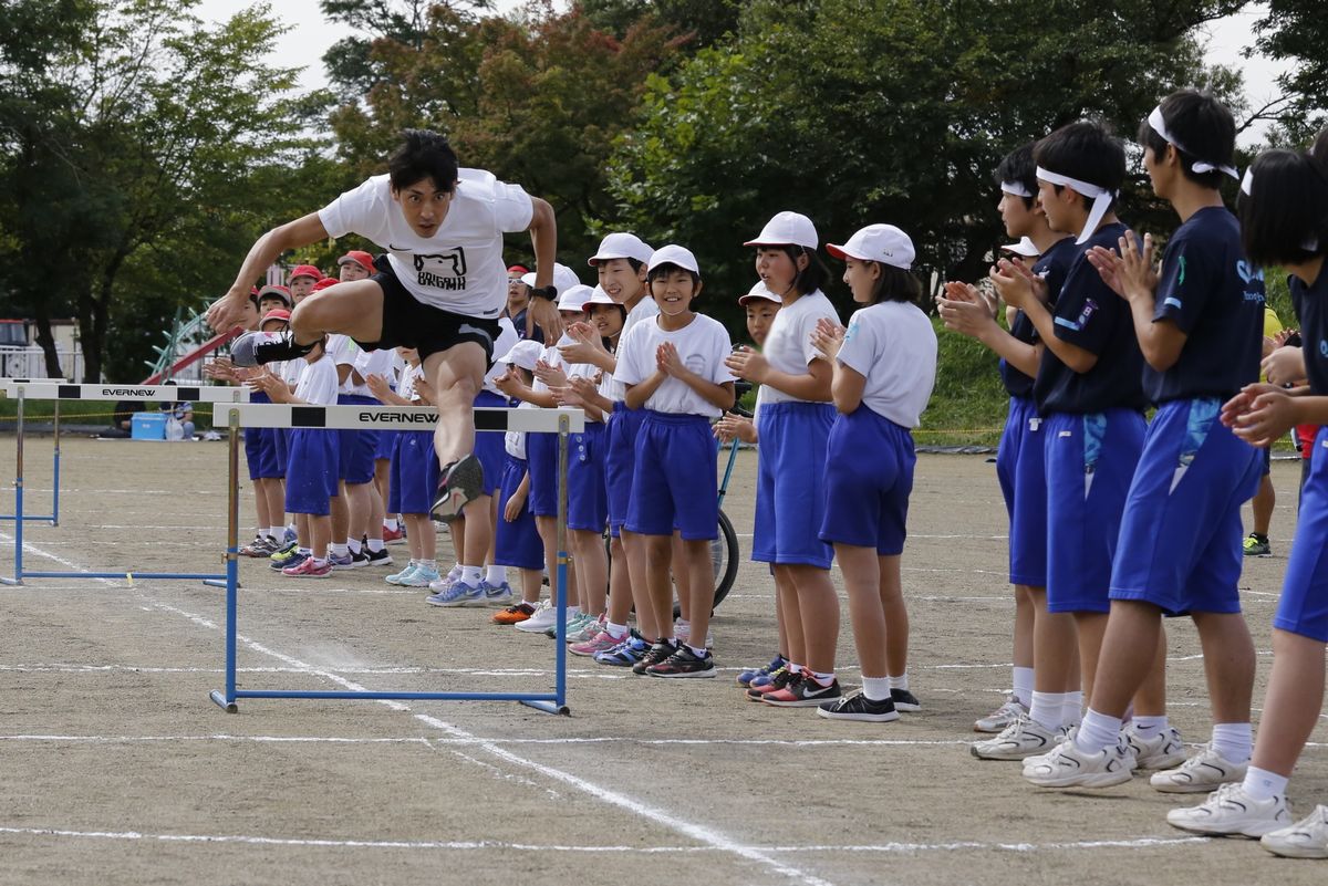 町出身の陸上競技選手秋本真吾さんのハードル実技に拍手を送る子どもたち
