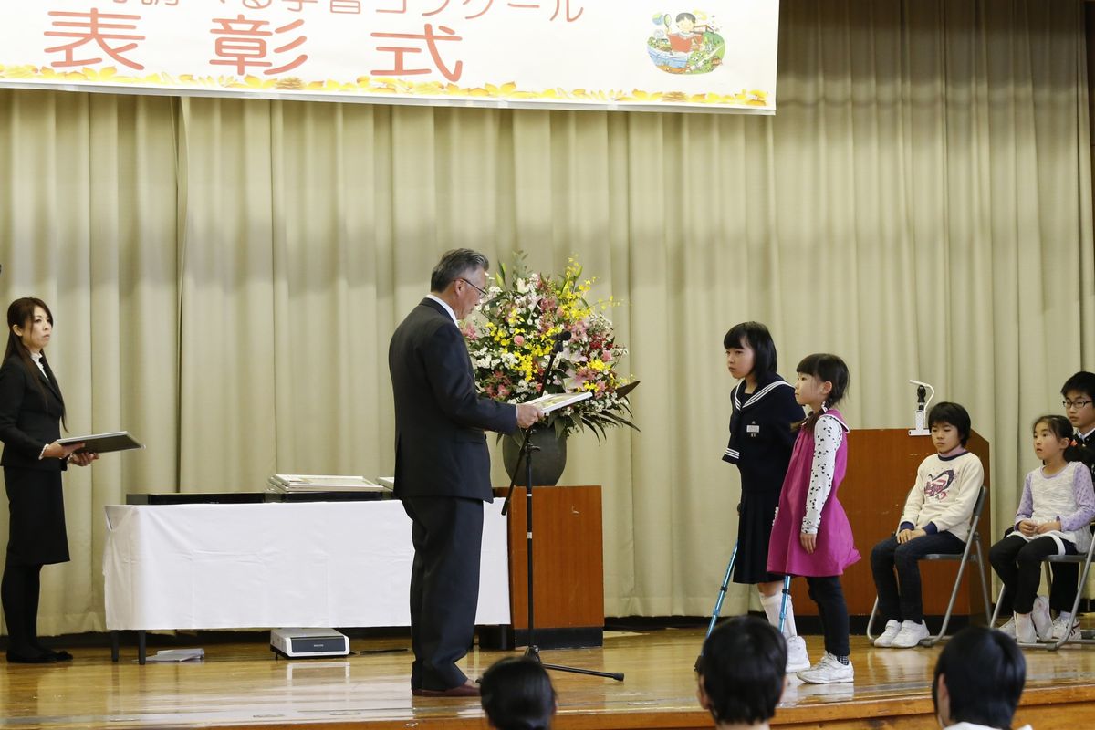 商工会長から表彰される二人の児童