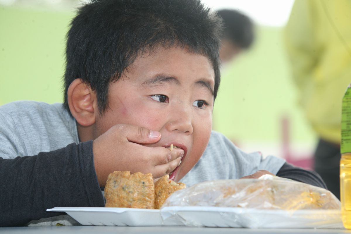 「Oh~!!いなり大早食い大会」でいなり寿司を口に詰め込む男の子