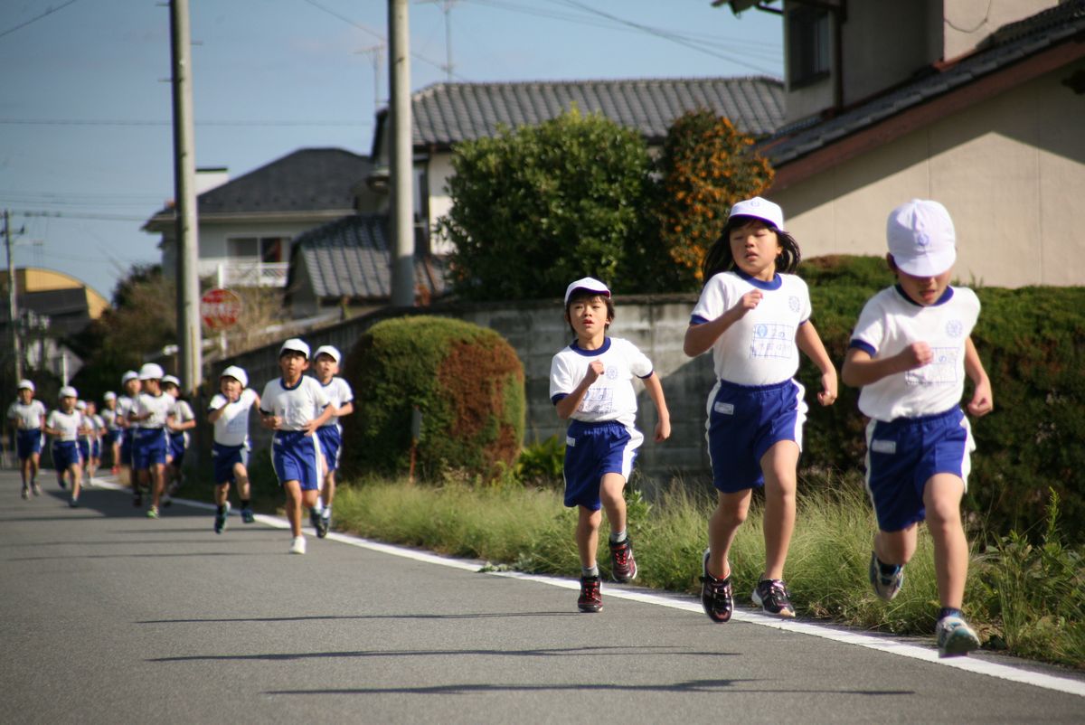 秋晴れの中、小学校外周を懸命に走る2年生
