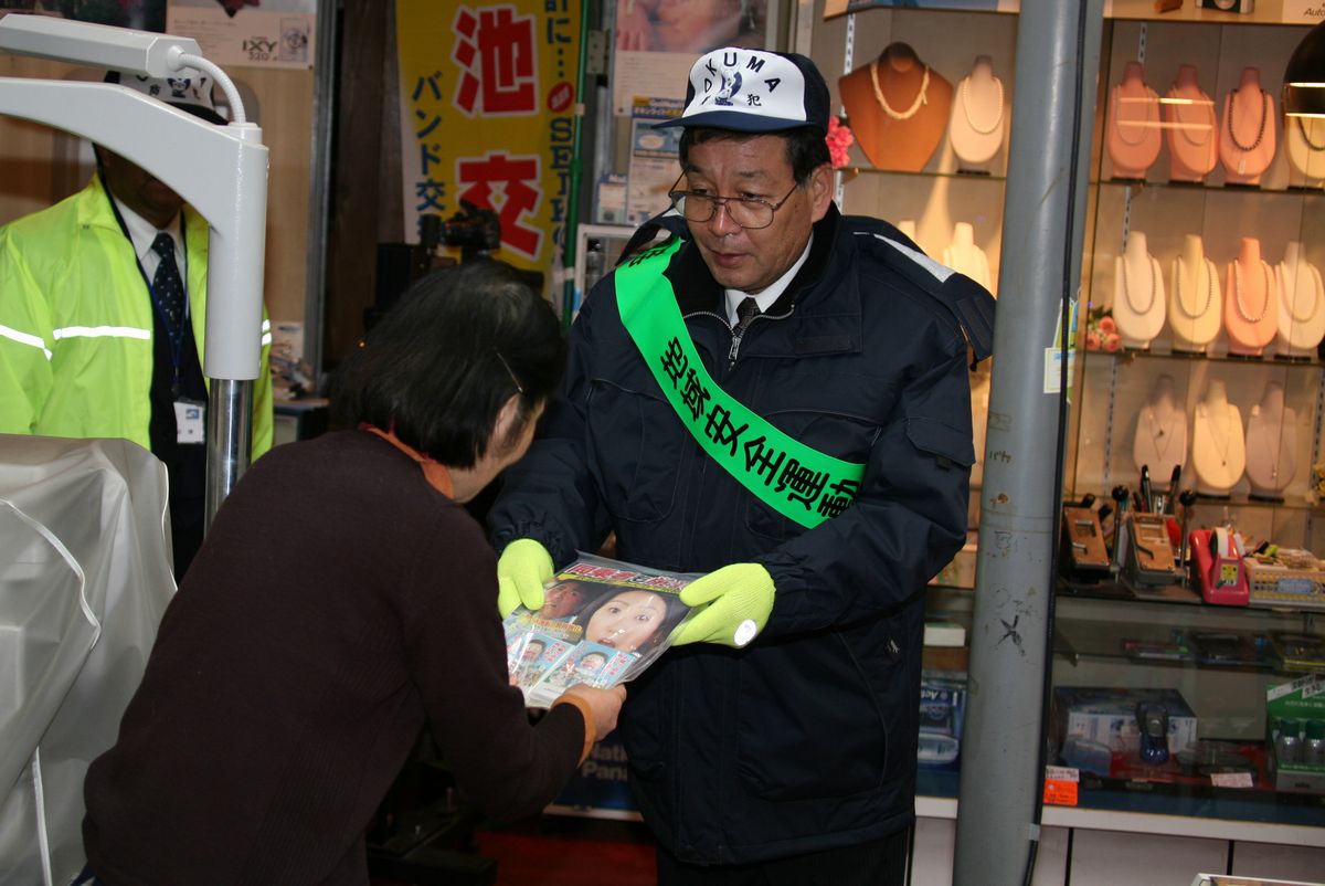 防犯協会長の渡辺町長から飲酒運転根絶のチラシを受け取る飲食店の方