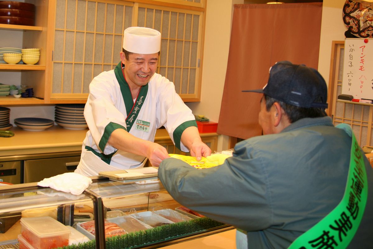 鈴木副町長からチラシを受け取る飲食店の方