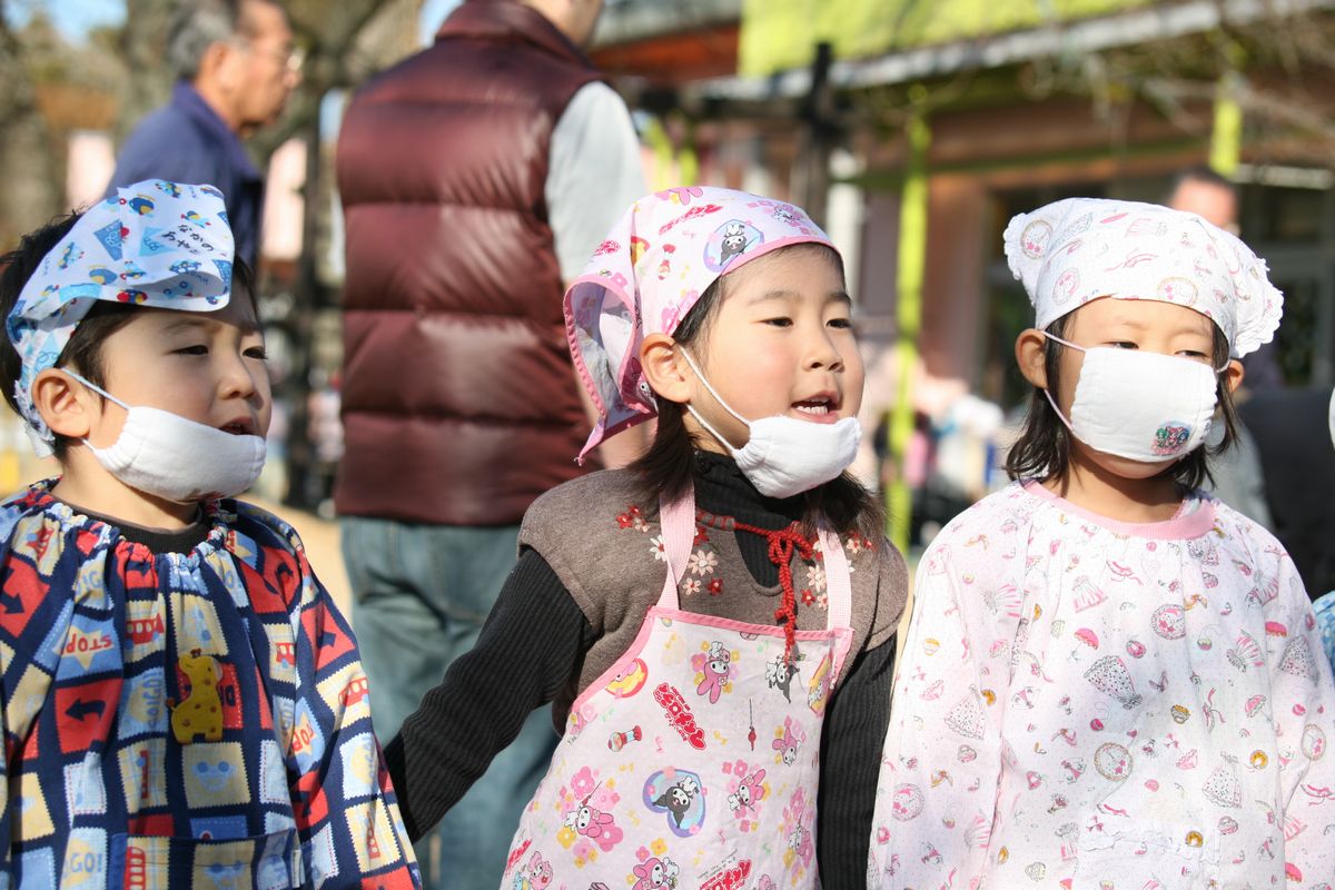 臼を囲んで「よいしょ！よいしょ！」とかけ声をかける園児