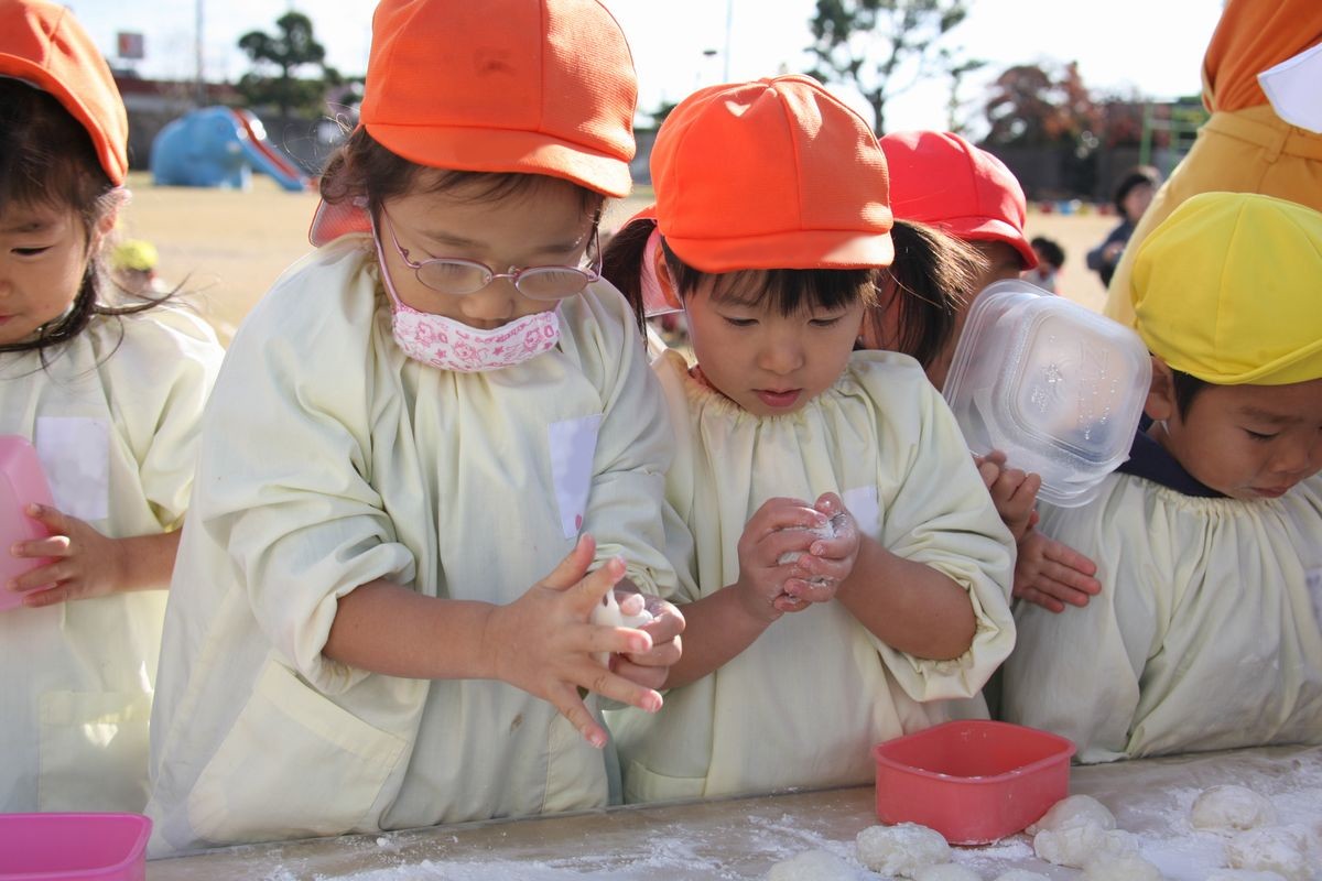 手を真っ白にして、つきあがったもちを嬉しそうに丸める子どもたち