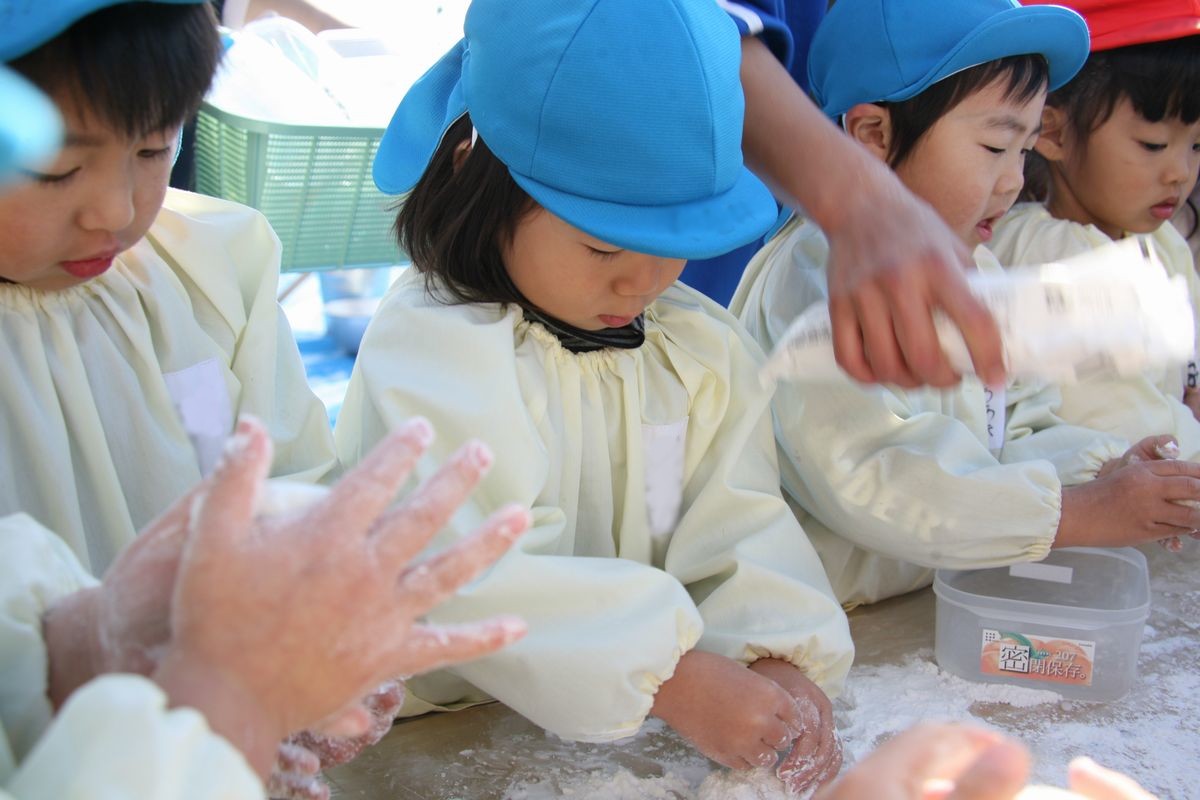 手を真っ白にして、つきあがったもちを嬉しそうに丸める子どもたち（2）