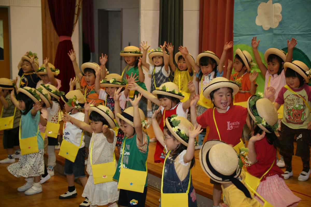 花を飾った麦わら帽子をかぶりとても楽しそうに踊る園児たち
