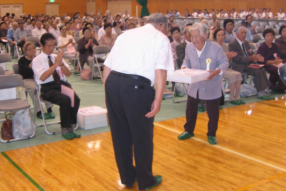 志賀町長から記念品を贈られるお年寄り（2）