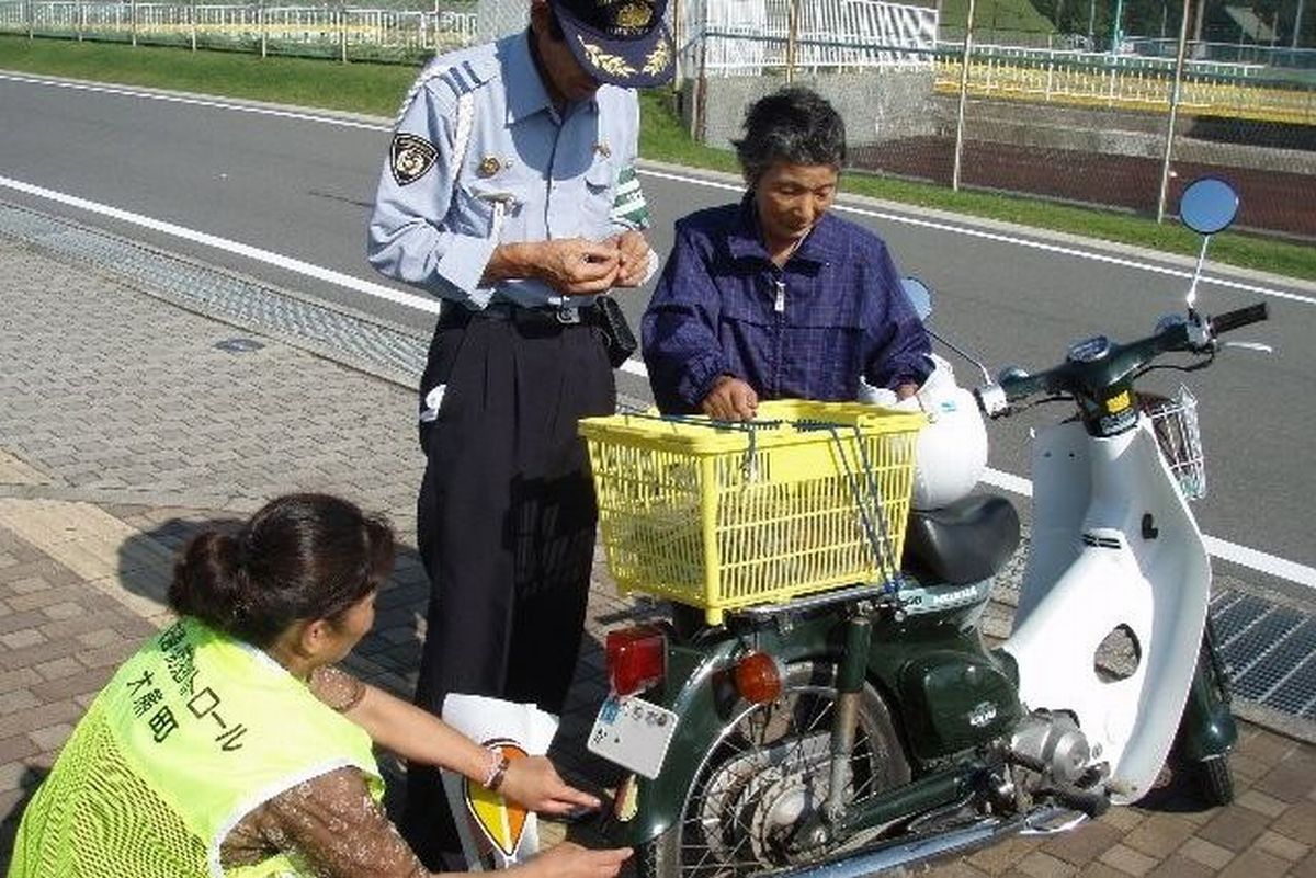 高齢ドライバーのバイク後方に「もみじマーク」のステッカーを貼る関係者