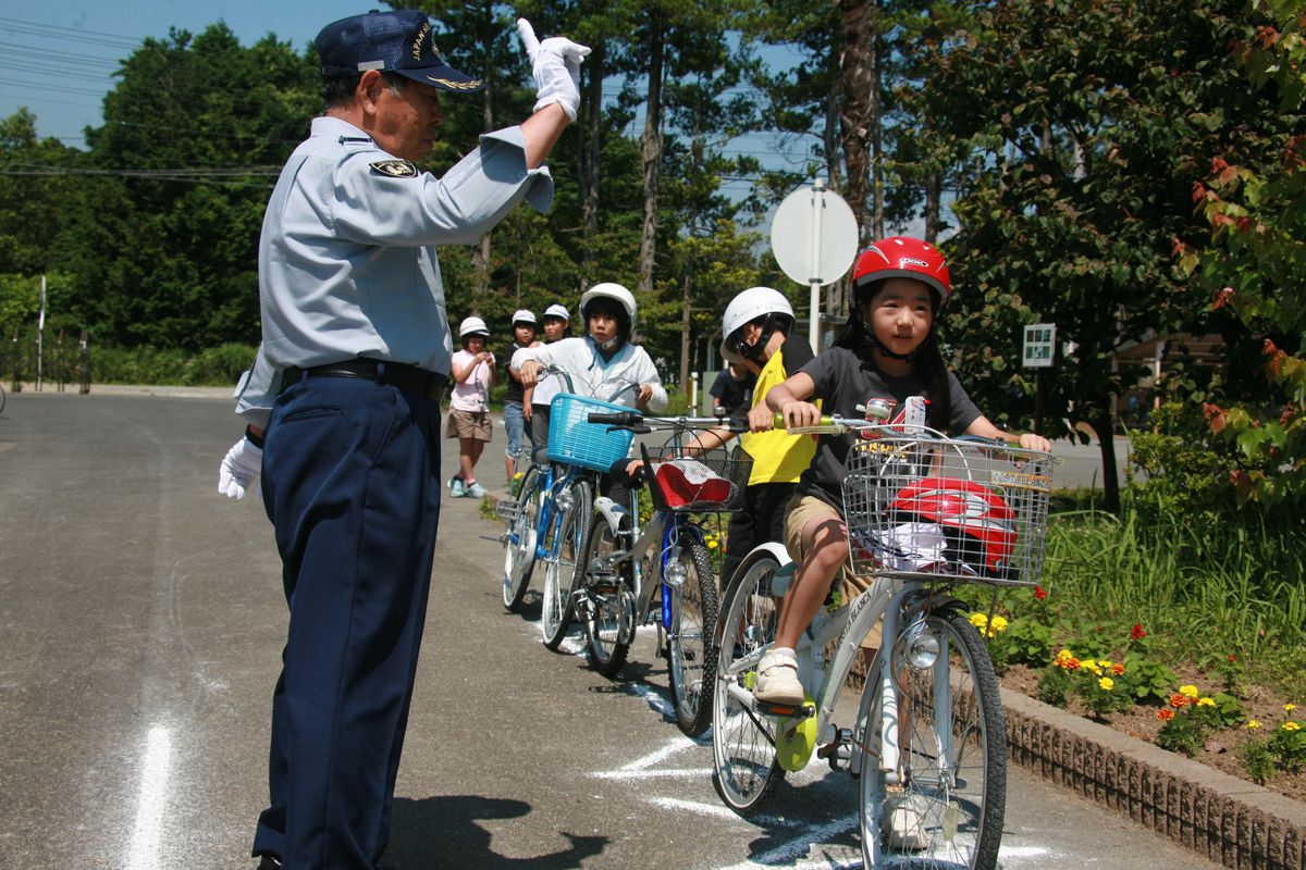 交差点で安全確認の指導を受ける児童