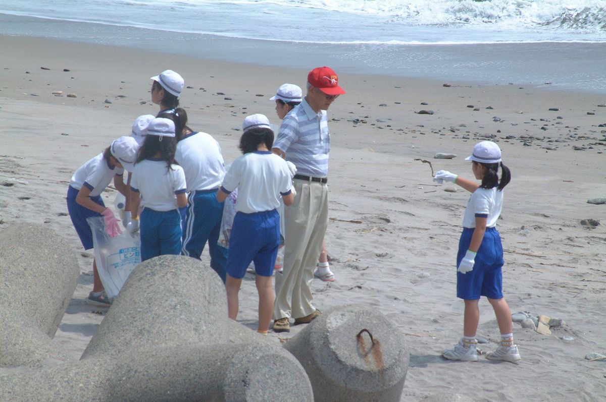 海岸に捨てられた空き缶や木くずなどを拾い集める熊町小学校の4年生（2）