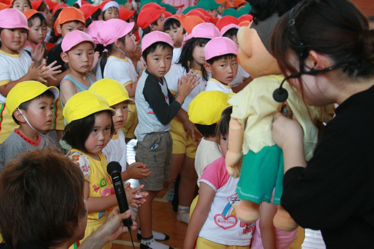 おはなし隊から質問されマイクを向けられる小学1年生