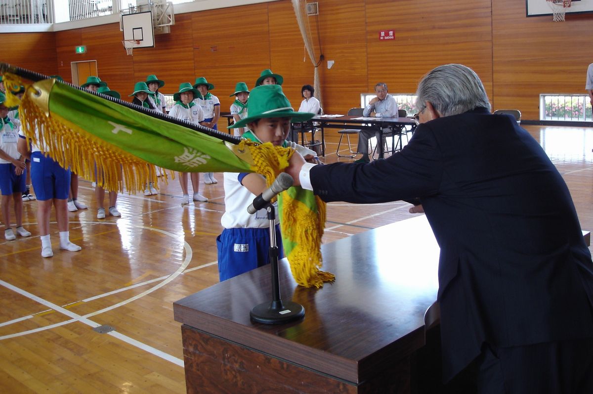 志賀町長から団旗を贈られる「緑の少年団」副団長