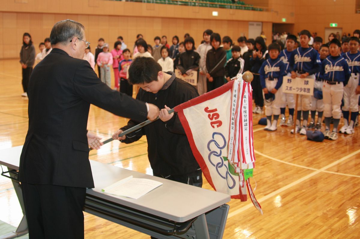 武内教育長から団旗を贈られる団員代表